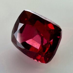 Natural cushion cut red spinel from Burma, exhibiting a rare raspberry color and excellent clarity, ideal for fine jewelry and gemstone collections.